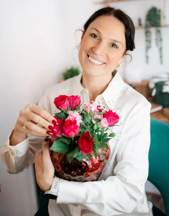attSIxQ-e2phiCmzrLHjfuGzrsXgsmSu6lUn5_sAvZB3B0 Kam smiling while holding a bouquet of flowers.